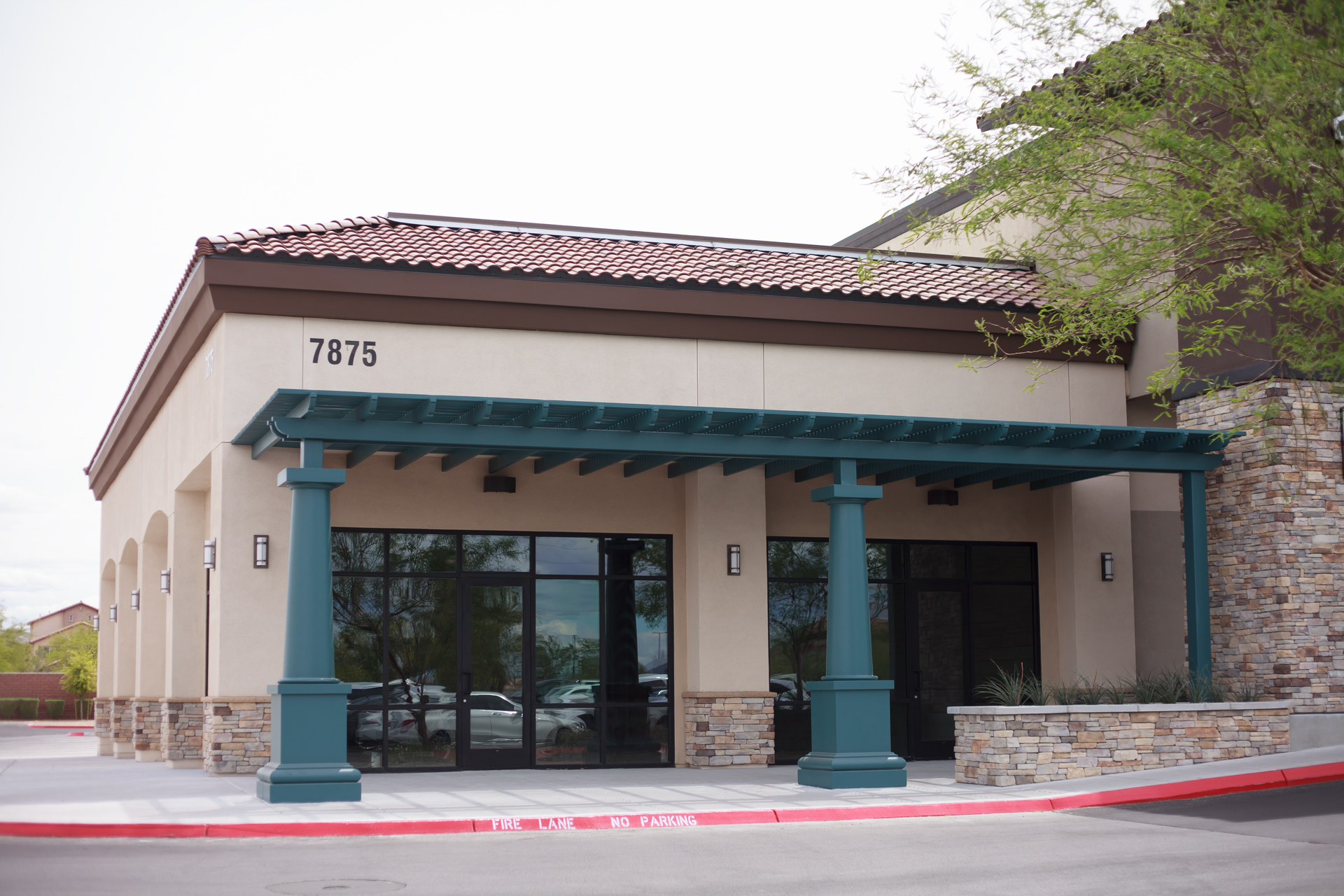 A building with a green roof and pillars on the front.