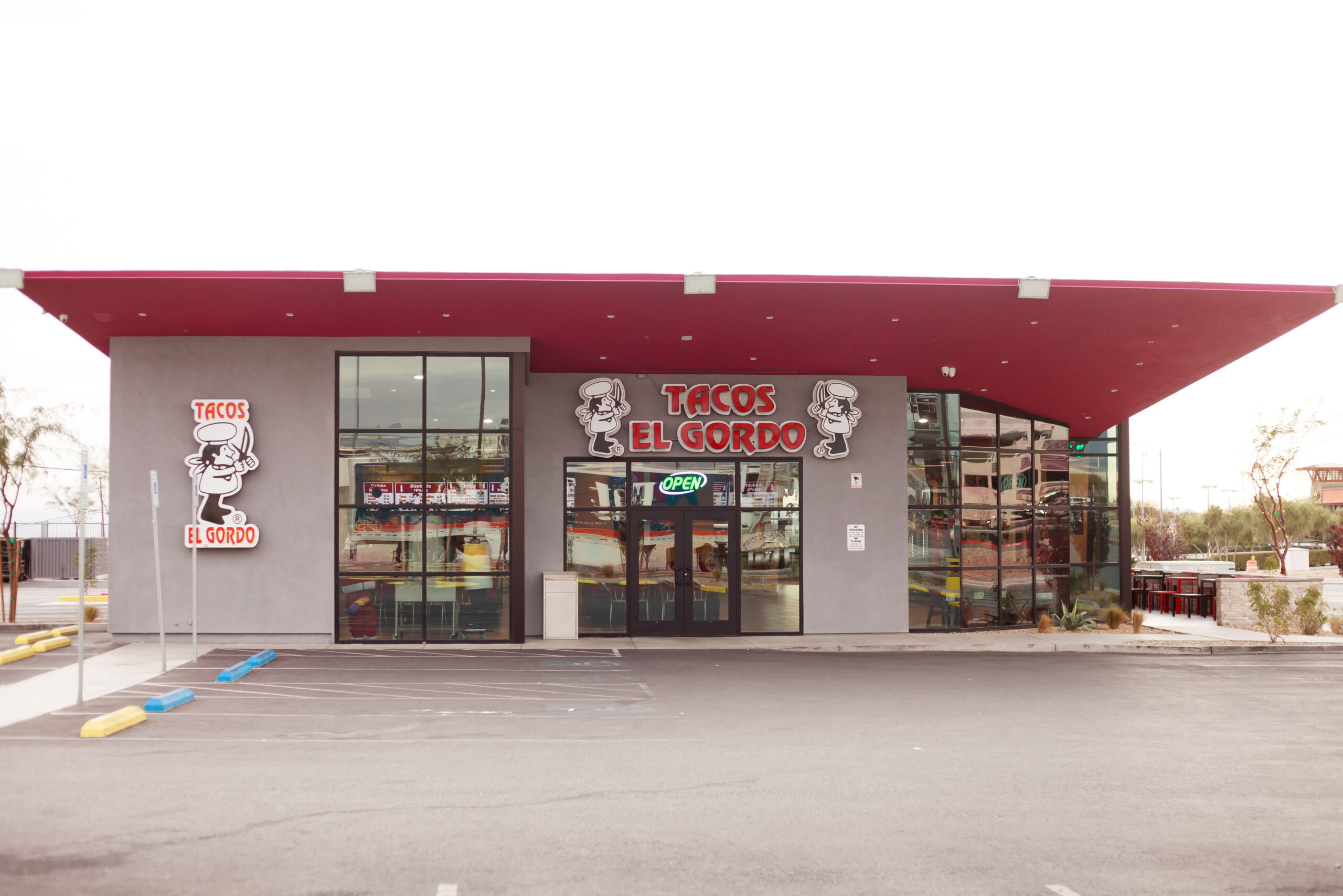 A store front with lots of windows and signs.